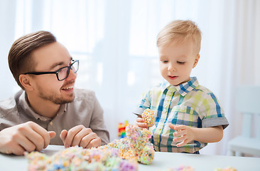 Image showing father and son playing with ball clay at home