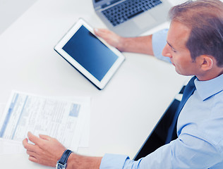 Image showing businessman with tablet pc and papers in office