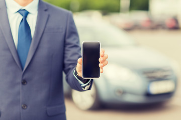 Image showing close up of business man with smartphone and car