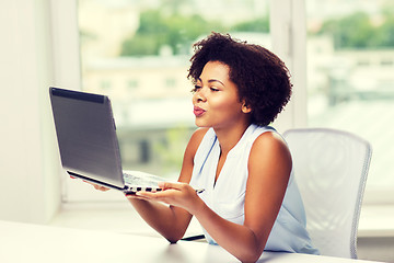 Image showing african woman sending kiss to laptop computer