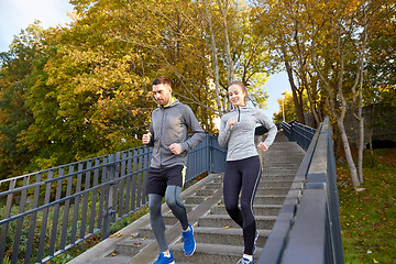 Image showing happy couple running downstairs in city