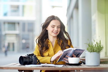 Image showing happy woman with guide drinking cocoa at city cafe