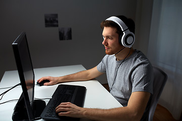 Image showing man in headset playing computer video game at home