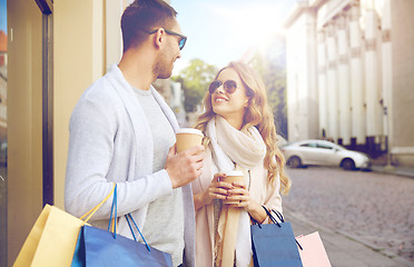 Image showing happy couple with shopping bags and coffee in city