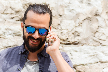 Image showing smiling man with smartphone calling on city street