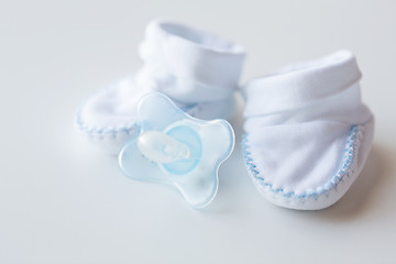 Image showing close up of baby bootees and soother for newborn