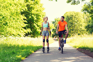 Image showing happy couple with roller skates and bicycle riding