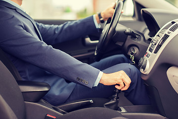 Image showing close up of young man in suit driving car