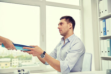 Image showing businessman taking papers from secretary in office