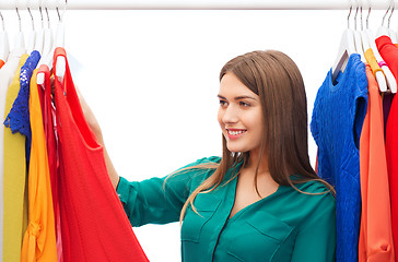 Image showing happy woman choosing clothes at home wardrobe