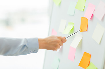 Image showing close up of hand pointing to sticker on flip chart