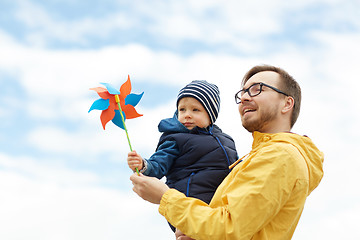 Image showing happy father and son with pinwheel toy outdoors