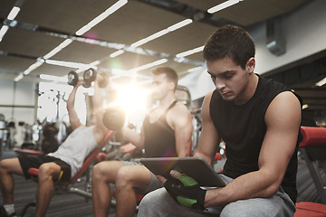 Image showing group of men with tablet pc and dumbbells in gym