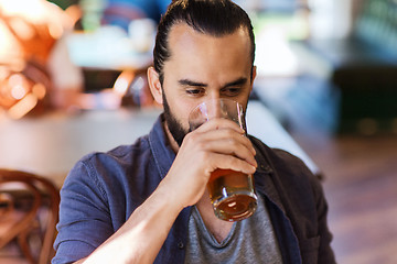 Image showing happy man drinking beer at bar or pub