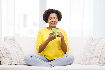 Image showing happy african woman with smartphone and earphones