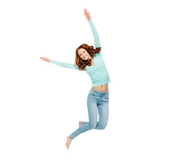 Image showing smiling young woman jumping in air