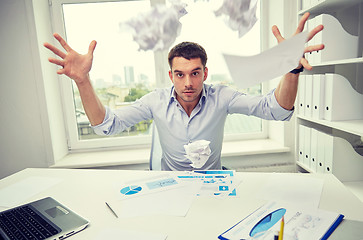 Image showing angry businessman throwing papers in office