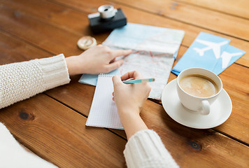 Image showing close up of traveler hands with notepad and pencil