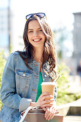 Image showing happy young woman drinking coffee on city street