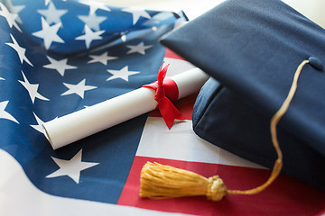 Image showing bachelor hat and diploma on american flag