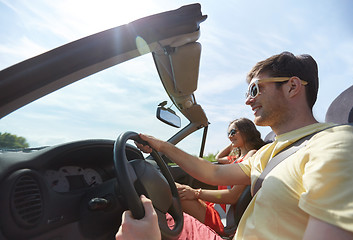 Image showing happy couple driving in cabriolet car at country