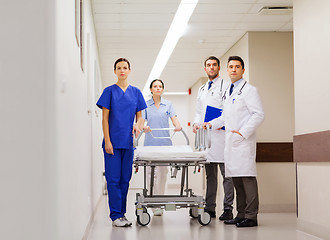 Image showing group of doctors with gurney at hospital