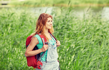 Image showing smiling young woman with backpack hiking in woods