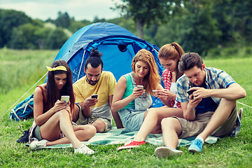 Image showing friends with smartphone and tent at camping