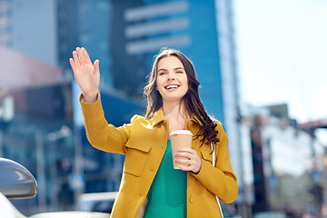 Image showing happy young woman drinking coffee on city street