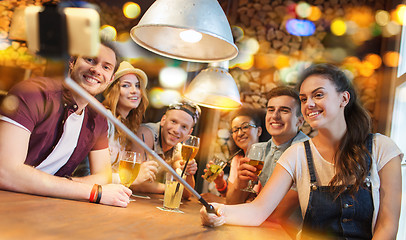 Image showing friends with smartphone on selfie stick at bar