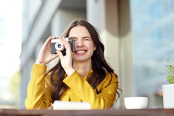 Image showing happy tourist woman with camera at city cafe