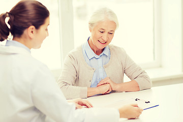 Image showing doctor with clipboard and senior woman at hospital