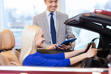 Image showing happy woman with car dealer in auto show or salon