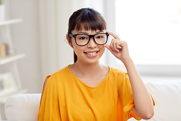 Image showing happy asian young woman in glasses at home