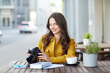 Image showing happy tourist woman with camera at city cafe