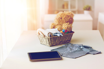 Image showing close up of baby clothes, toys and tablet pc