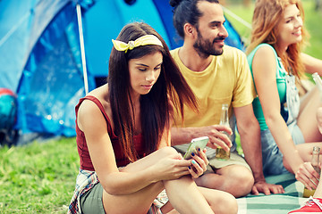 Image showing happy woman with smartphone and friends at camping