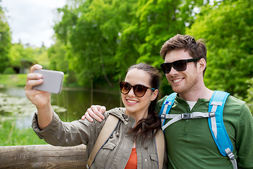 Image showing couple with backpacks taking selfie by smartphone