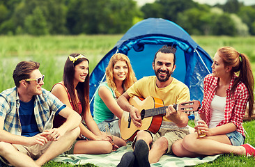 Image showing happy friends with drinks and guitar at camping