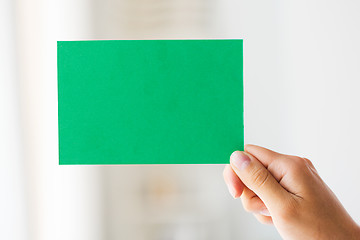 Image showing close up of hand holding green paper card