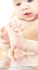 Image showing bathing baby in mother hands