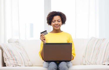 Image showing happy african woman with laptop and credit card