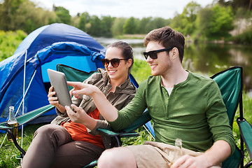 Image showing happy couple with tablet pc at camping tent