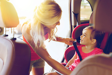 Image showing happy mother fastening child with car seat belt