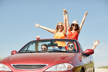 Image showing happy friends driving in cabriolet car at country