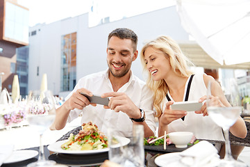 Image showing happy couple with smatphone photographing food