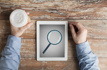 Image showing close up of male hands with magnifier on tablet pc