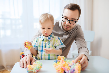 Image showing father and son playing with ball clay at home