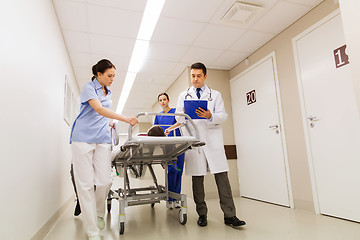 Image showing medics with woman on hospital gurney at emergency