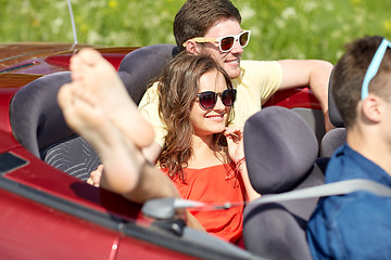 Image showing happy friends driving in cabriolet car outdoors